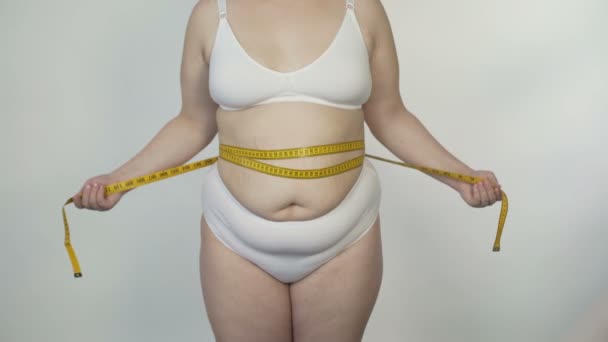 Senhora motivada tomando medidas da barriga e procurando maneiras de perder peso — Vídeo de Stock