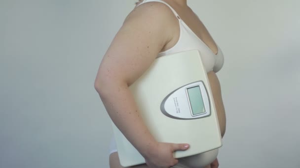 Gewichtscontrole, vette vrouw in lingerie houden schalen en poseren voor de camera — Stockvideo