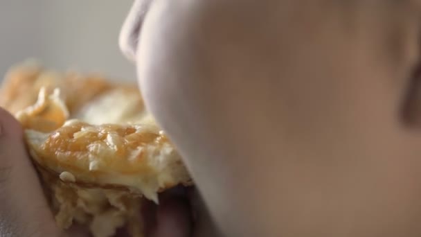 Gordita hembra mordiendo rebanada de pizza con apetito, comida poco saludable, sobrepeso — Vídeos de Stock