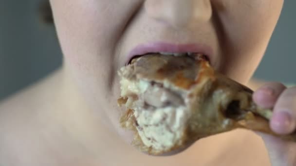 Παχύσαρκα πεινασμένος κορίτσι δάγκωμα κομμάτι λιπαρά κοτόπουλου στη σχάρα, χοληστερόλη και υπερβολικό βάρος — Αρχείο Βίντεο