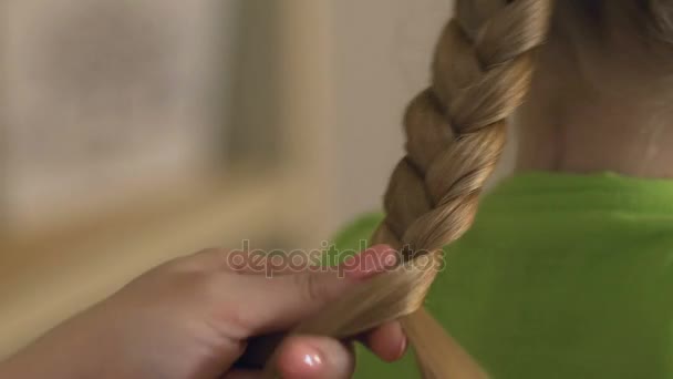 Mãe trançando o cabelo da filha loira, penteado, relações familiares e cuidados — Vídeo de Stock