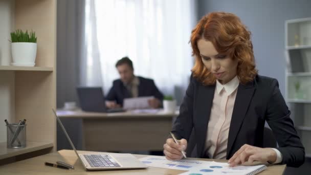 Señorita marcando diagramas estadísticos en el escritorio, contemplando resultados, informe anual — Vídeos de Stock