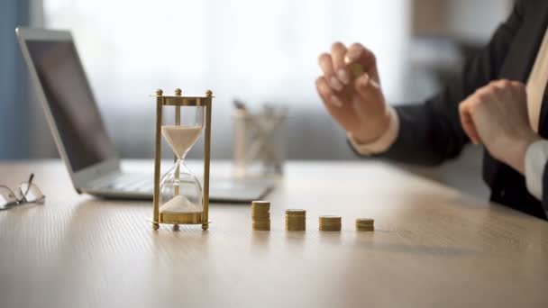 Lady adding coin to stack on office desk, bank earning interests, repaying loan — Stock Video