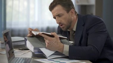Kafa kağıtları yığının üstüne koyarak defter, açılış Yöneticisi listelemek için okuma yorgun
