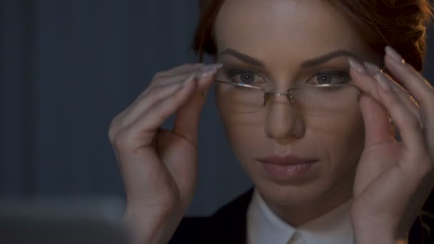 Dame portant des lunettes, travaillant avec un ordinateur portable, reflet d'écran dans ses lunettes — Video