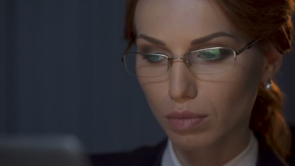Бізнес-леді знімає окуляри і уважно дивиться на екран ноутбука — стокове відео