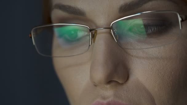 Laptop screen reflected in glasses, female working on laptop, concentration — Stock Video