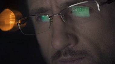 Dizüstü ekran dosyaları ile gözlük yansıyan geceleri, dizüstü bilgisayarda çalışan adam