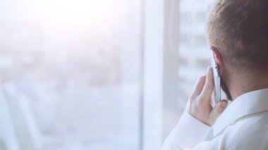 Mutlu işadamı ailesine yakın pencere, iletişim cep telefonu konuşurken