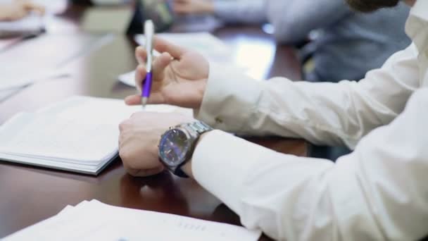 Verveeld werknemer zit op handelsconferentie en spinnen een pen in zijn handen — Stockvideo