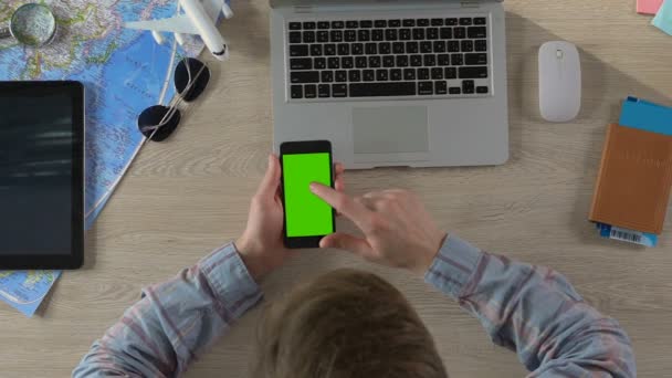 Homem rolando no smartphone com tela verde e escolhendo hotel para férias — Vídeo de Stock