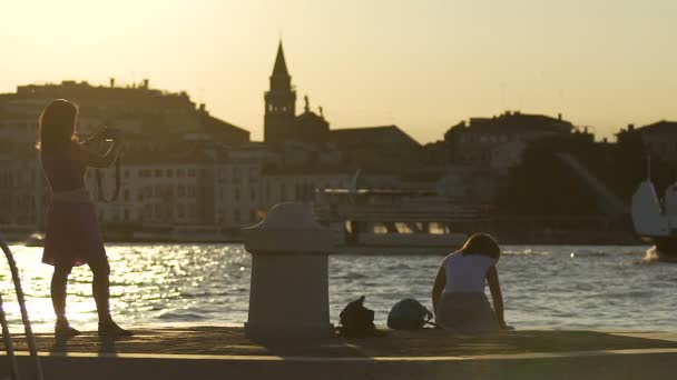 Female students enjoying seaside cityscape, taking photos on pier, tour to Italy — Stock Video