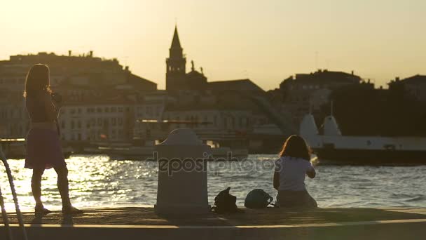 イタリア、ヴェネツィアの夕日を楽しんでいる若い女性の二人旅行スローモーション — ストック動画