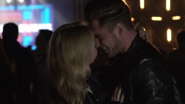Man hugging and kissing girlfriend at night club, couple enjoying concert — Stock Video