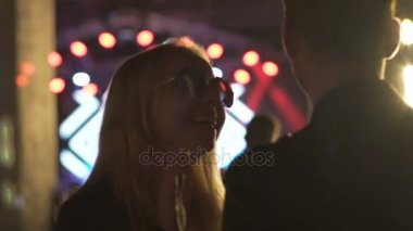 Saç sallayarak ve erkek gece kulübünde dans güneş gözlüklü sarışın kız