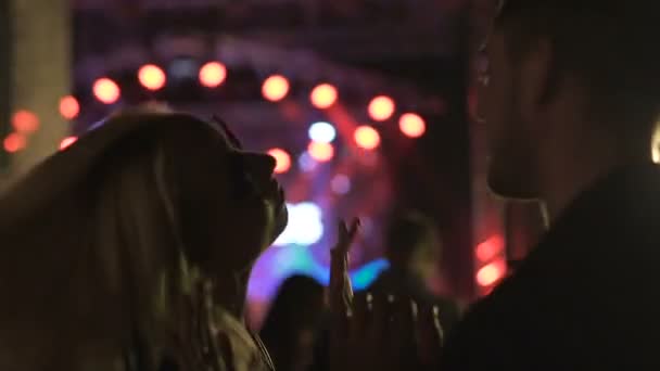 Young woman dancing with boyfriend and shaking hands at rock festival, relax — Stock Video