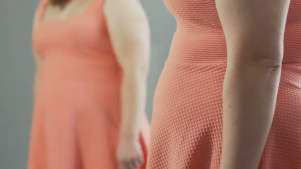 Woman pulling back dress and looking at her flabby stomach reflected in mirror — Stock Footage Woman pulling back dress and looking at her flabby stomach reflected in mirror Royalty Free Stock Footage