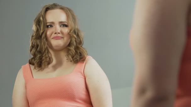 Депрессивная толстая девушка, глядя на свое отражение, отчаянно плакала — стоковое видео