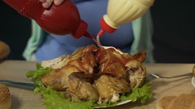 Genç kadın kızarmış tavuk mayonez ve ketçap, closeup dolu tepesi