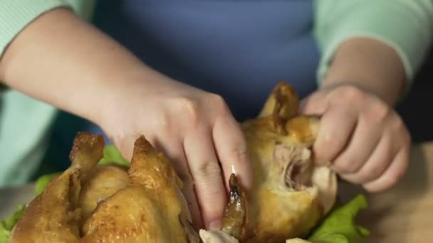 Mani di donna grassa con disturbo alimentare strappando carne di pollo arrosto intero — Video Stock