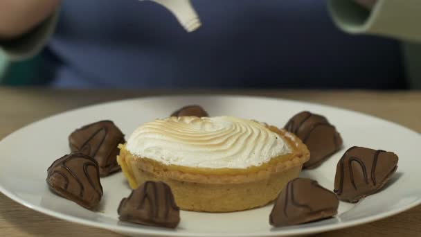 Donna obesa che copre abbondantemente dolci e cioccolatini con guarnizione caramello da vicino — Video Stock