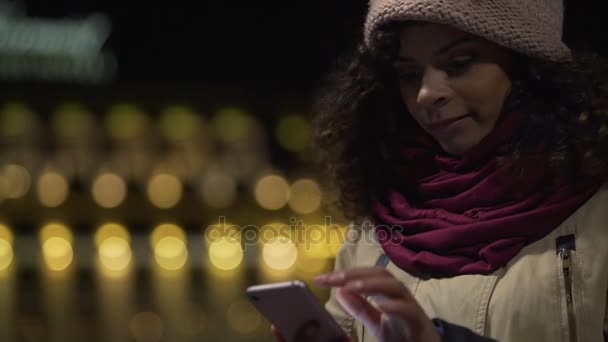 Lady kijken naar foto's op haar smartphone en glimlachen, mooie romantische herinneringen — Stockvideo