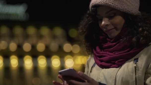Krásná dívka čtení romantické lásky korespondence na její mobil a usmívá se — Stock video
