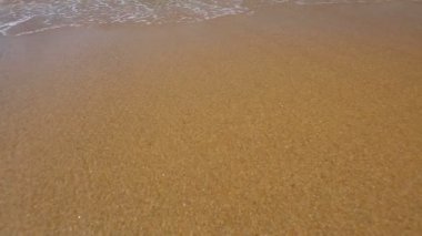 Hızlı altın kum sahil üzerine haddeleme ve ocean geri yıkama köpüklü dalgalar