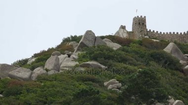 Taş duvara dik tepeye yürüme gösterilen kuvvetlendirici, kayalar yamaçta dağınık.