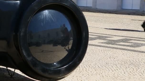 Турист приближается к большому объекту с огромным глазом и смотрит на свое отражение — стоковое видео