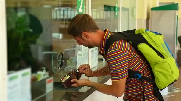 Турист шукає гроші в гаманці для оплати квитка на касі, вокзалі — стокове відео
