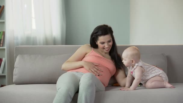 Schöne schwangere Frau berührt Bauch sanft, genießt Zeit mit niedlichem Baby — Stockvideo