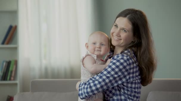 漂亮的年轻妈妈和可爱的小宝贝女儿拥抱和微笑，幸福的未来 — 图库视频影像