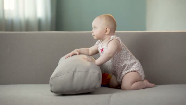 Lustiges fröhliches Baby-Mädchen springt auf Sofa und entdeckt die Welt in bequemen Windeln — Stockvideo