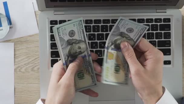 Podnikatel, počítání dolarové bankovky v jeho rukou, jejich uvádění na notebooku, příjem