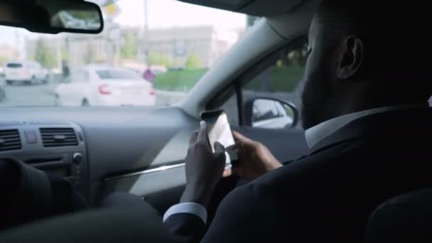 Afro-American affärsman kommer att möte, tittar genom frågor på telefon — Stockvideo