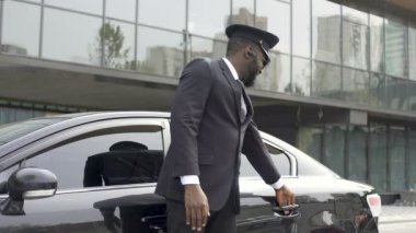 Kibarca arabanın kapısını açarak özenli taksi şoförü görüşmek istemci davet