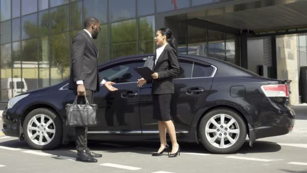 Carro showroom consultor mostrando ao comprador carro de luxo, contando sobre seus prós — Vídeo de Stock