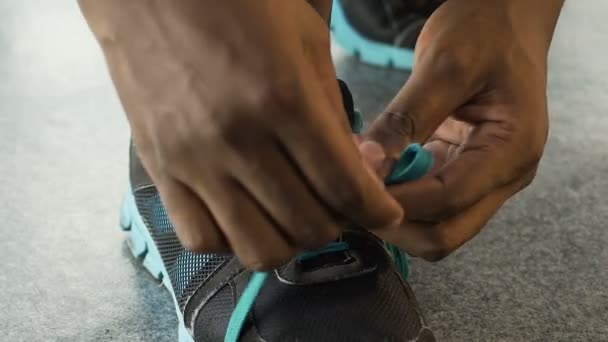 Çok ırklı adam kadar ayakkabı bağcığı bağlama ve bırakarak, basketbol oyuncusu, yakın çekim — Stok video