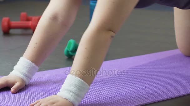 Flicka gör yoga på golvet, byte från barn till cobra pose, fysisk träning — Stockvideo