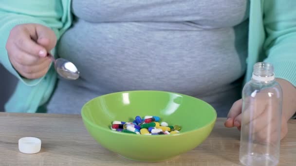 Menina tomando colher para comer comprimidos de tigela, câmera lenta, produtos farmacêuticos — Vídeo de Stock