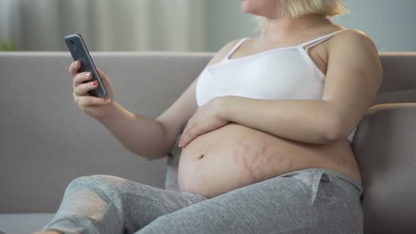 Verwacht vrouw verzenden van berichten over haar welzijn naar man, smartphone — Stockvideo