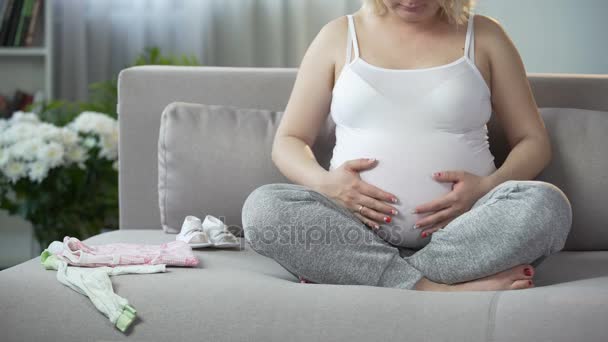 Groot met kind vrouw masseert haar buik kalmerende en ontspannende foetus binnen — Stockvideo
