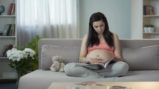 Felice donna incinta revisione catalogo, la scelta di mobili per la camera dei bambini — Video Stock