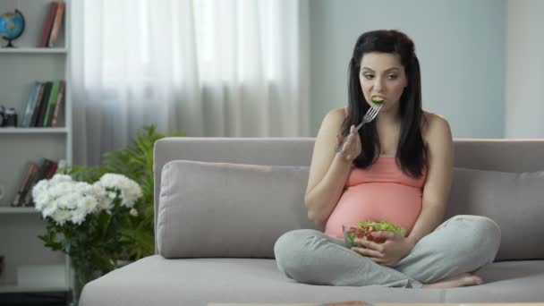 Беременная девушка соблюдает правильную диету, ест здоровый овощной салат, витамины — стоковое видео
