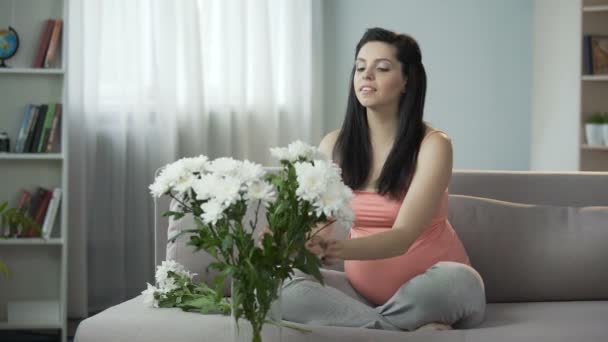 Vackra gravid tjej dekorera huset med fina blommor, estetisk njutning — Stockvideo