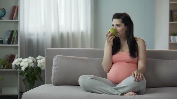 Chica embarazada que vive una forma de vida saludable, mordiendo manzana y encontrándola agria — Vídeo de stock