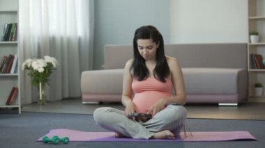 Kulaklıktaki koyarak ve çocuğunu sakinleştirici melodileri zevk bekleyen anne