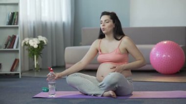 Bayan yapıyor yoga, içme suyu, güvenli doğum gebeliğin son dönemlerinde
