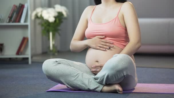 Будущая мамочка делает упражнения, общается и связывается со своим будущим ребенком — стоковое видео